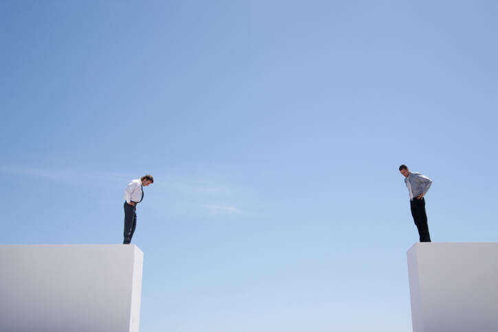 Two people on opposite blocks with a large gap between